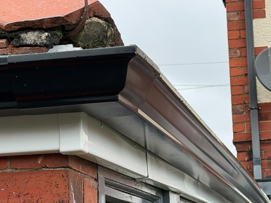 Close view of a 5 inch ogee seamless aluminium gutter curving round a bay window