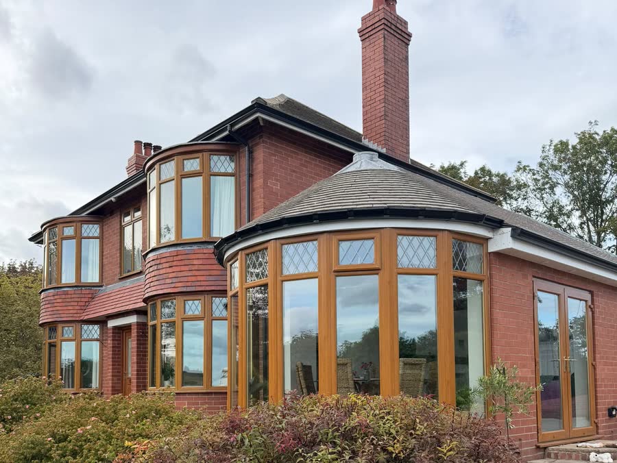 One unbroken length of black seamless aluminium guttering across the front elevation of a large brick house
