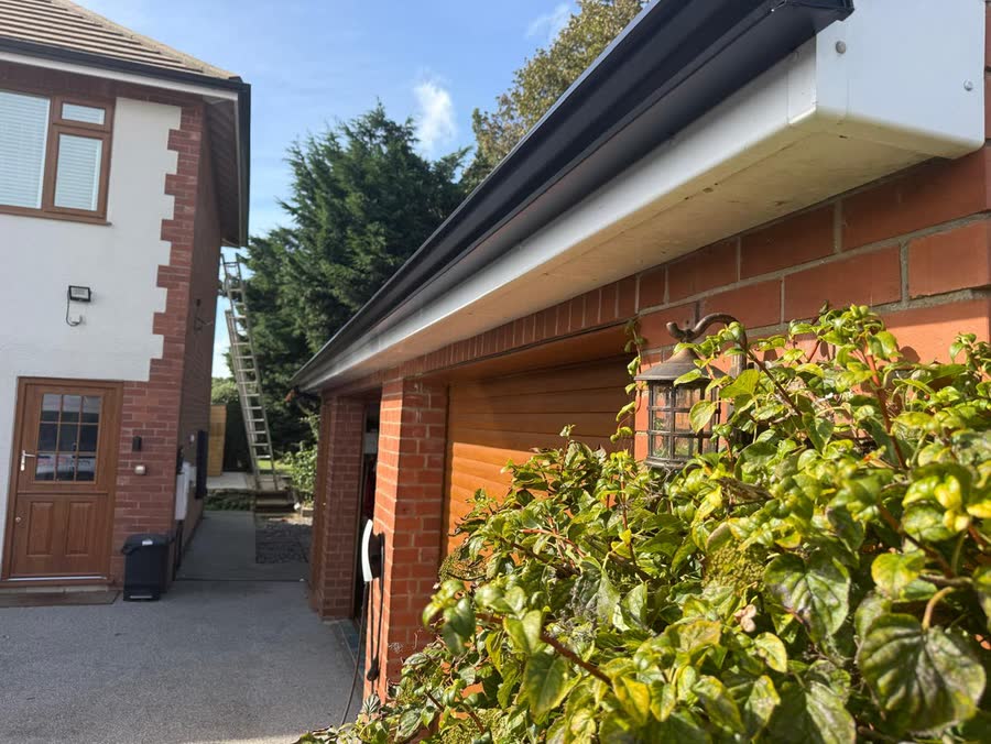 A single length of black seamless guttering across a double garage with white fascia